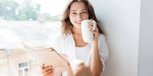Iloinen nainen juo kahvia